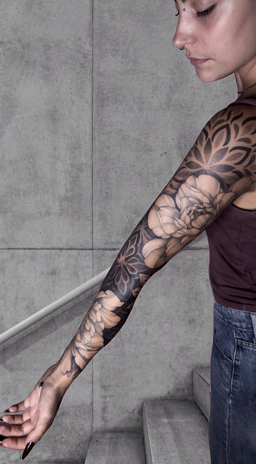 Profil mit ausgestrecktem Arm, ein ganzer Ärmel aus schattierten Blüten und geometrischen Mandalas.